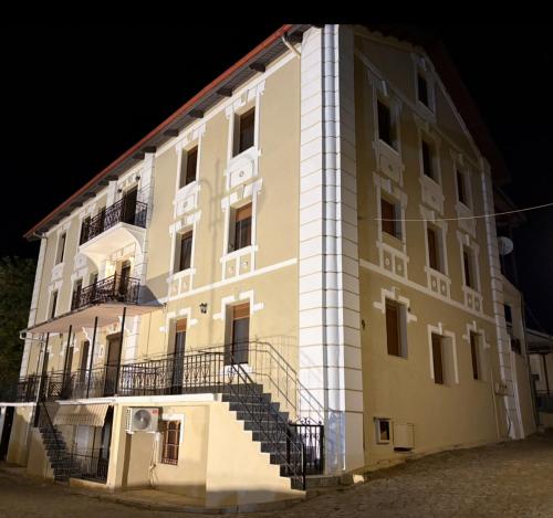 a large building with stairs on the side of it at Καπνομάγαζο Λαδιά in Próti