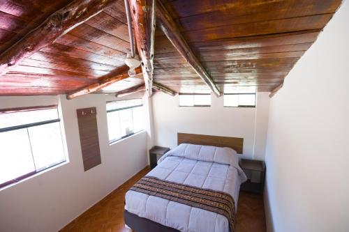 a bedroom with two beds and a wooden ceiling at Refugio Sagrado Boutique in Ollantaytambo