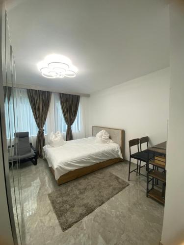 a bedroom with a white bed and a table and chairs at Downtown Apartment in Bonn