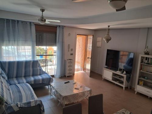 a living room with a couch and a tv at House Parra in San Juan de los Terreros