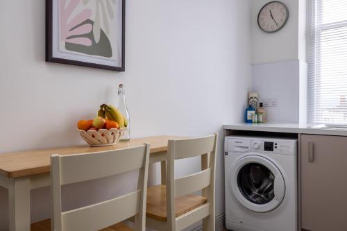 a kitchen with a table and a washing machine at Antonine Quarters in Grahamston