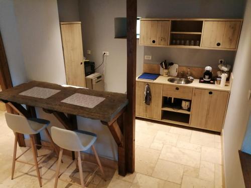 a small kitchen with a wooden table and chairs at La Longère du Manoir in Laniscat