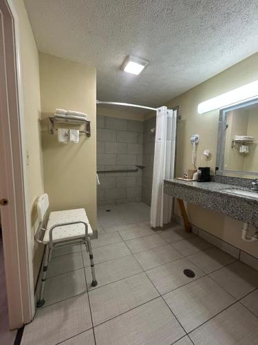 a bathroom with a chair and a sink and a shower at Deerfield Inn in Parsons