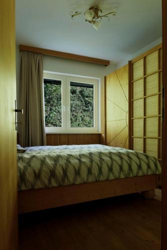 a bedroom with a bed and two windows at Charmantes Einfamilienhaus in Größing