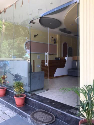 a glass building with potted plants on the steps at HOTEL FRIENDs in Varanasi