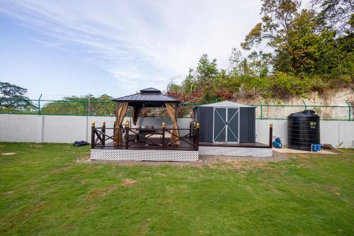a gazebo with a table in a yard at Sunset Sea-renity Villa in Belle Air Summit