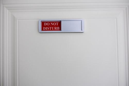 a door with a do not disturb sign on it at Sunset Sea-renity Villa in Belle Air Summit