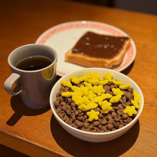 a bowl of cereal and a cup of coffee and a plate of toast at Wink at Perak Road in Singapore