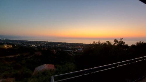 a sunset over a city with the ocean in the background at Casa del Sole in Capo dʼOrlando