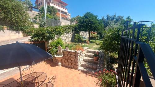 a patio with an umbrella and a brick wall at Casa del Sole in Capo dʼOrlando