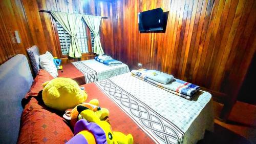 a bedroom with two beds and a teddy bear on a couch at Encarnacion House in Encarnación