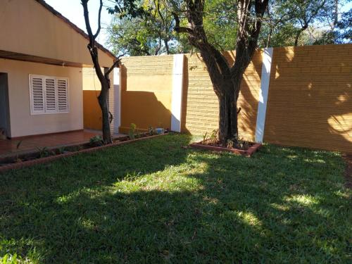 a yard with two trees next to a house at Encarnacion House in Encarnación