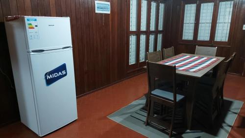 a kitchen with a refrigerator and a table with chairs at Encarnacion House in Encarnación