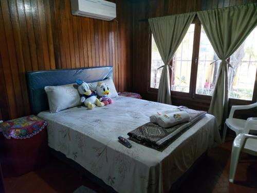 a bedroom with a bed with two teddy bears on it at Encarnacion House in Encarnación