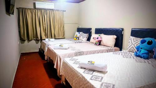 a room with two beds with stuffed animals on them at Encarnacion House in Encarnación