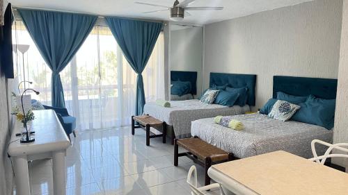 a living room with two beds and a table at Front Beach Studio in Cancún