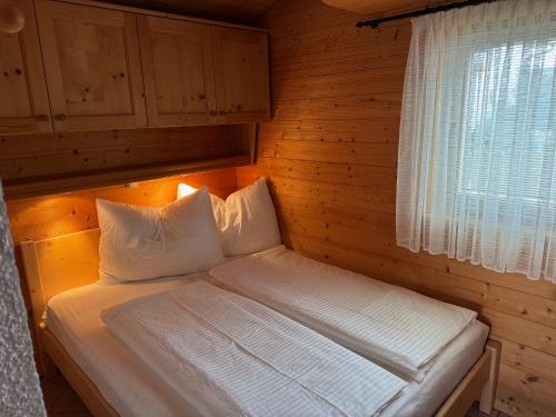 a small bed in a room with a window at Ferienwohnung Top 5 in Altmünster