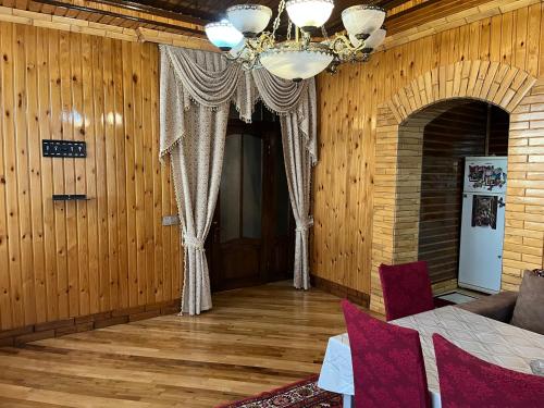 a living room with a chandelier and wooden walls at Sheki Modern Guest Home in Sheki