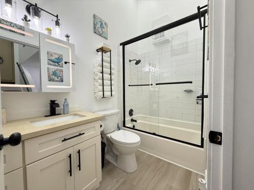 a bathroom with a toilet and a glass shower at Modern 3BR Townhouse near UW in Seattle