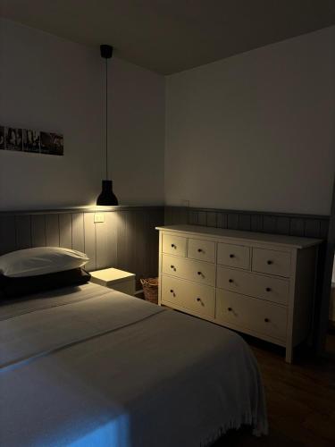 a bedroom with a white bed and a dresser at La Pausa in Portoferraio