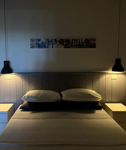 a bed with two pillows in a bedroom with two lights at La Pausa in Portoferraio