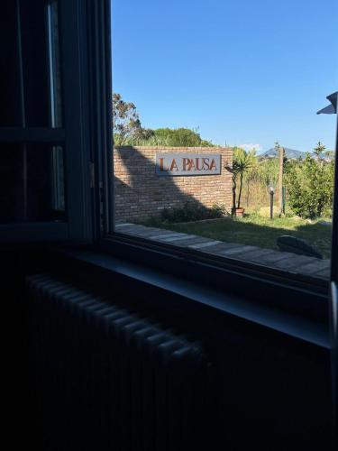 a window with a view of a sign in a brick wall at La Pausa in Portoferraio