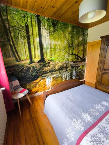 a bedroom with a forest mural on the wall at la berlie du jura in Étival