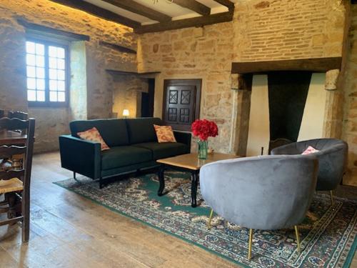 a living room with a couch and a table at Maison du Chapitre in Prudhomat