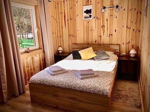 Przycup w Karkonoszach Apartamenty Słoneczna dolina 7B - domek na wyłączność w Karkonoszach في Mniszków: غرفة نوم مع سرير في غرفة خشبية
