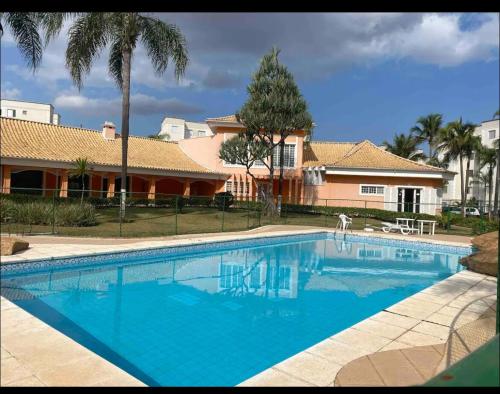 索罗卡巴Moderno e aconchegante ao lado do Iguatemi的房子前面的一个蓝色大游泳池