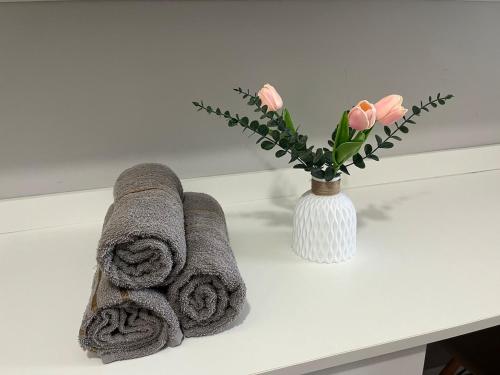 索罗卡巴Moderno e aconchegante ao lado do Iguatemi的白色的桌子,带毛巾,花瓶