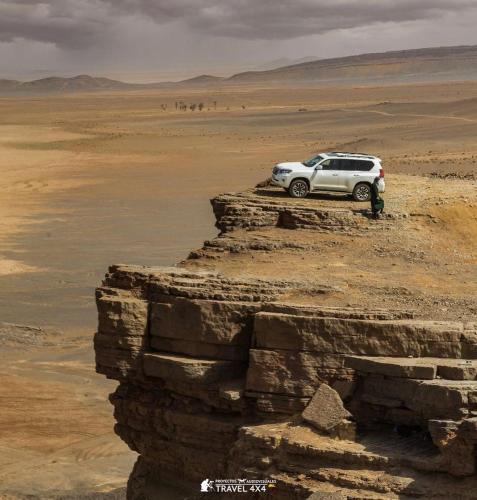 a car parked on the edge of a cliff in the desert at Cafe Restaurant Moove Oil in Rissani