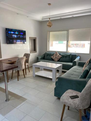 a living room with a green couch and a table at Cozy Relax in Mohammedia