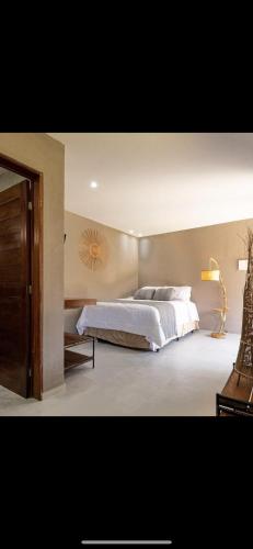 a bedroom with a large white bed in it at Casa Zouk, charme e alto padrão in Japaratinga