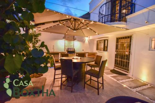 a patio with a table and chairs and an umbrella at Casa Boxtha in Ixmiquilpan