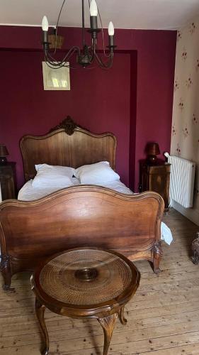 a bed with a wooden frame and a coffee table at Petite maison de brocanteur à Charbonnières in Charbonnières-les-Bains