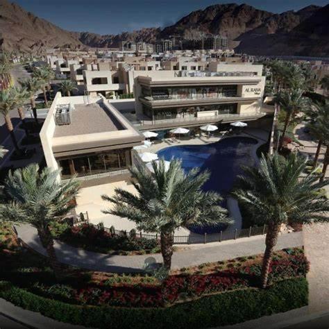 an aerial view of a building with palm trees at Flow - Al Raha Village in Aqaba