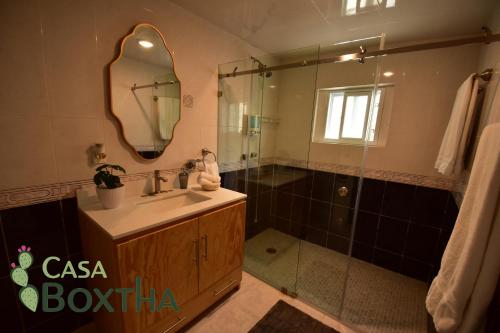 a bathroom with a sink and a shower with a mirror at Casa Boxtha in Ixmiquilpan