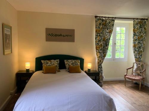 a bedroom with a large bed and a window at Maison du Chapitre in Prudhomat