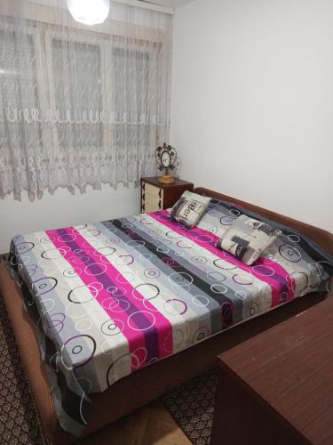 a bedroom with a bed with a colorful comforter at Apartman Markovic in Vranje