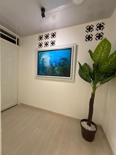 a room with a plant and a painting on the wall at Hospedarte Cali Sur in Cali