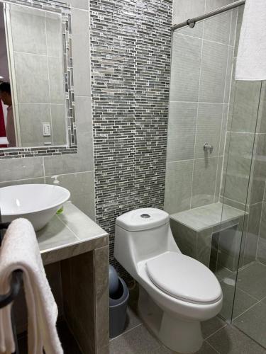 a bathroom with a toilet and a sink and a shower at Hospedarte Cali Sur in Cali