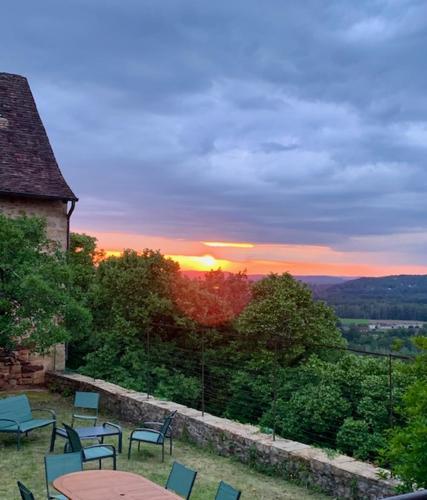 a group of chairs sitting around a table with a sunset at Maison du Chapitre in Prudhomat