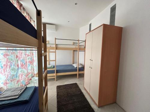a room with two bunk beds and a closet at Peaceful apartment with yard and parking in Skopje
