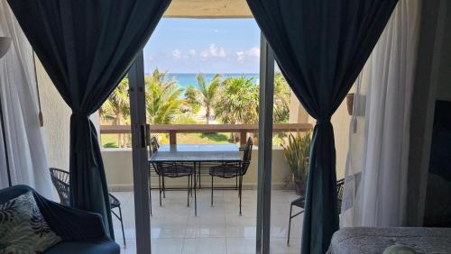 a balcony with a table and chairs and the ocean at Front Beach Studio in Cancún