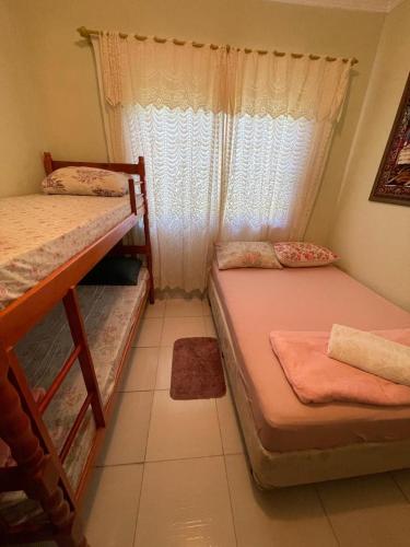 a bedroom with two bunk beds and a window at Hostel e Pousada Vó Lili in Joinville