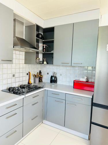 a kitchen with white cabinets and a stove at Villa-gey Escape in Bekkevoort