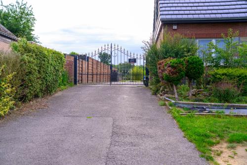 a driveway with a gate in front of a house at Villa-gey Escape in Bekkevoort