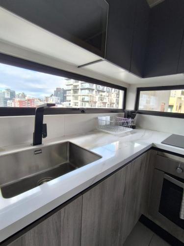a kitchen with a sink and a large window at Panoramic Terrace ESSENCE Luxury Suite in Carolina Park in Quito