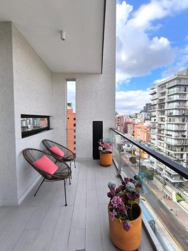 a balcony with chairs and flowers on a building at Panoramic Terrace ESSENCE Luxury Suite in Carolina Park in Quito